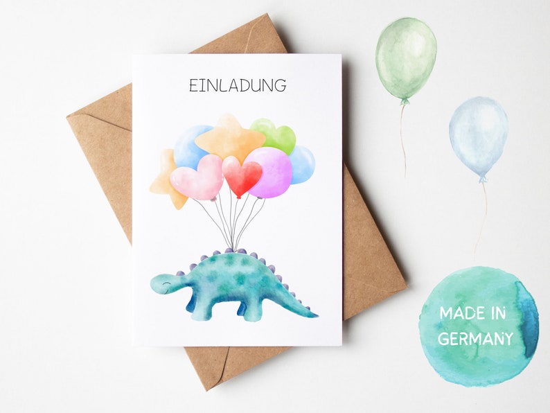 May include: A white card with the word "Einladung" printed in black. A green dinosaur with a purple spine is holding up a bunch of colorful balloons. The balloons are pink, red, orange, yellow, green, and blue. The card is sitting on a brown envelope. A green watercolor circle with the text "Made in Germany" is in the lower right corner.