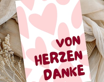 Op de afbeelding: Een rechthoekige wenskaart met een witte achtergrond en een herhalend patroon van lichtroze harten. De tekst VON HERZEN DANKE staat in het midden gedrukt in een vet, donkerrood, afgerond schreefloos lettertype.