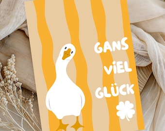 May include: A rectangular greeting card featuring a white goose with an orange beak and feet against a background of vertical wavy yellow and beige stripes. The text GANS VIEL GLÜCK is printed in white, accompanied by a white four-leaf clover icon.