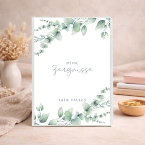 Könnte beinhalten: Ein weißer Ordnerumschlag mit einem Aquarell-Eukalyptusblatt-Design oben und unten. Der Text lautet "MEINE Zeugnisse" in einer Mischung aus Serif- und Schreibschrift, gefolgt von dem Namen "KATHI PAULUS" in einer einfachen serifenlosen Schrift.