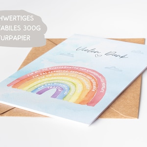 Op de afbeelding: Een lichtblauwe kaart met een regenboog en de tekst "Vielen Dank" in wit. De regenboog heeft tekst op elke streep, waaronder "Voor alle kleurrijke en prachtige momenten", "Voor het geduld en begrip", "Voor de knuffels en knuffels", "Voor het lachen en de vreugde", "Voor het vertrouwen en de troost", "Voor de kussen en de liefde", "Voor de verhalen en liedjes".