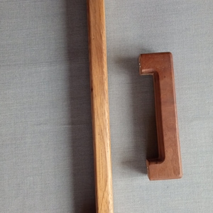 Könnte beinhalten: Zwei Holzknaufgriffe für Schranktüren. Der größere Griff ist hellbraun und der kleinere ist dunkelbraun.