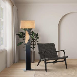 May include: A modern floor lamp with a rectangular tan lampshade and a black base. The lamp features a half-moon design with a light wood finish. A gray woven chair sits nearby, creating a contemporary living room scene.