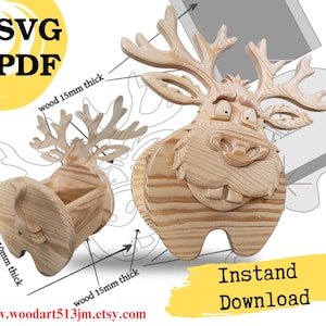 May include: A wooden moose head wall mount and a matching wooden moose container, both featuring a light natural wood grain. The image includes text labels indicating wood thicknesses of 10mm and 15mm, along with the text SVG, PDF, and Instand Download.