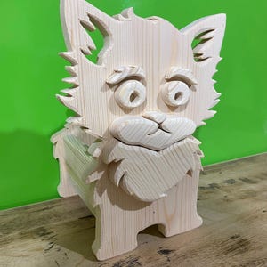 May include: A wooden sculpture of a dog with a whimsical design. The dog has large, round eyes, a fluffy beard, and pointed ears. The sculpture is made of light-colored wood and stands on four legs. The background is a solid green color.