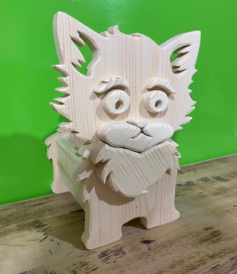 May include: A wooden sculpture of a dog with a whimsical design. The dog has large, round eyes, a fluffy beard, and pointed ears. The sculpture is made of light-colored wood and stands on four legs. The background is a solid green color.