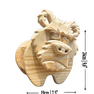 May include: A wooden sculpture of a bull with a detailed, carved design. The sculpture is 9.6 inches tall and 7.5 inches wide. The bull has horns, a snout, and expressive eyes. The wood has a natural, light brown color.