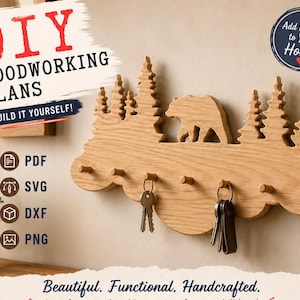 May include: A light brown wooden wall-mounted key holder featuring a laser-cut silhouette of a bear walking through a forest of pine trees. The rack includes six small pegs for hanging keys, with two sets of keys currently hanging from the hooks.