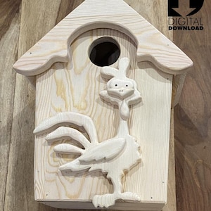 May include: Wooden birdhouse with a rooster design. The birdhouse is made of natural wood and has a small opening for birds to enter. The rooster is carved into the front of the birdhouse and has a detailed design.