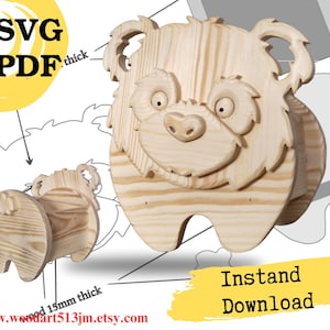 Puede incluir: Un proyecto de manualidades de madera con forma de oso con un diseño 3D. El oso tiene una cara sonriente y está hecho de madera de color claro. La imagen incluye el texto "SVG PDF" y "Descarga instantánea".