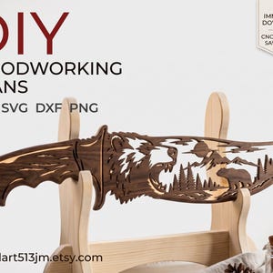 May include: A dark brown wooden cutout shaped like a knife, featuring an intricate laser-cut design of a roaring bear, a mountain range, and a forest. The text reads DIY WOODWORKING PLANS PDF SVG DXF PNG and IMMEDIATE DOWNLOAD CNC & SCROLL SAW READY.