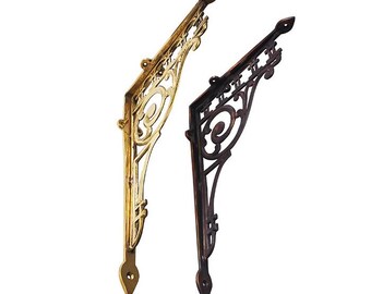 May include: Two decorative metal shelf brackets, one in gold and one in black. Both brackets have an ornate design with a floral motif.