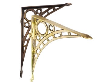 May include: Two decorative metal shelf brackets, one gold and one bronze, with a circular and geometric design.