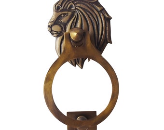 Aldrava de porta em formato de cabeça de leão com anel de esfera. Latão fundido com acabamento em latão clássico.