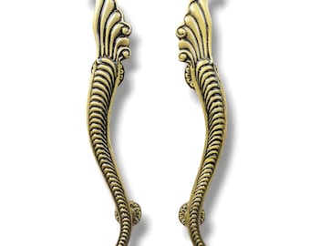 May include: A pair of ornate gold door handles with a decorative, swirling design. The handles are made of metal and have a polished finish.