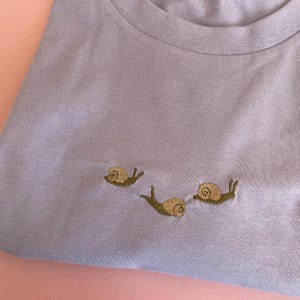 Snail T-Shirt with snails embroidered.