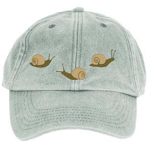 May include: A light gray baseball cap with an embroidered design of three snails. The snails are brown with green shells and are moving in a line.