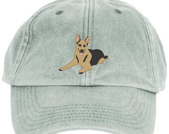 May include: A light green, distressed, cotton baseball cap with an embroidered image of a German Shepherd dog.