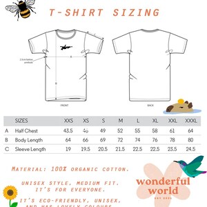 Puede incluir: Tabla de tallas de camiseta con medidas en pulgadas para la mitad del pecho, la longitud del cuerpo y la longitud de la manga. Las tallas van de XXS a XXXL. La tabla est&aacute; impresa sobre un fondo blanco con una ilustraci&oacute;n de abeja en la parte superior y una ilustraci&oacute;n de capibara en la parte inferior. El texto "T-shirt Sizing" est&aacute; impreso en naranja en la parte superior de la tabla. El texto "Material: 100% Organic Cotton." est&aacute; impreso debajo de la tabla. El texto "Unisex style, medium fit. It's for everyone. It's eco-friendly, unisex, and has lovely colours." est&aacute; impreso debajo de la descripci&oacute;n del material. El texto "wonderful world est 2021" est&aacute; impreso en un c&iacute;rculo rosa con una ilustraci&oacute;n de colibr&iacute;.