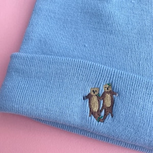 Otters geborduurde beanie, otters hand in hand, geborduurde otters, beanie, veganistisch, zeeotter, rivierotter