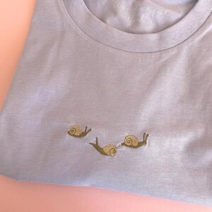 Snail T-Shirt with snails embroidered.