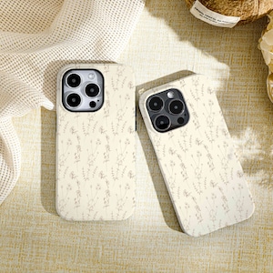 May include: Two white phone cases with a floral pattern. The cases have a raised camera bump and a cutout for the phone's charging port.