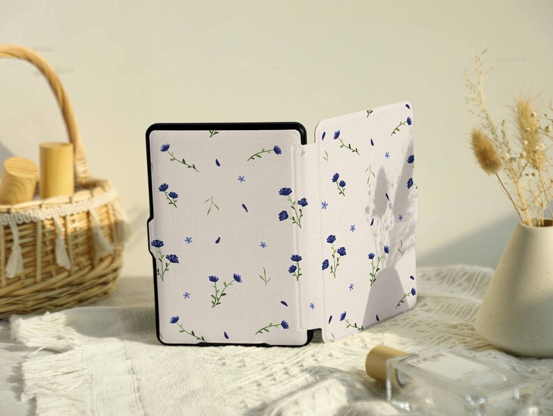 May include: A white and blue floral patterned e-reader case with a black e-reader inside.