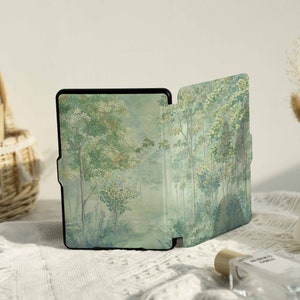 May include: A black e-reader with a forest scene cover. The cover is a watercolor painting of trees and foliage in shades of green, blue, and white.