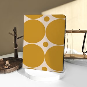 Könnte beinhalten: Eine iPad-Hülle mit einem weißen Hintergrund und großen gelben Kreisen, die ein geometrisches Muster bilden.