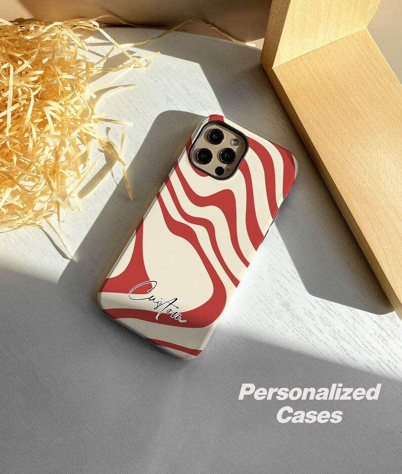 May include: A white and red phone case with a wavy pattern and the word "Custom" written in black. The case is designed for a phone with a camera bump.