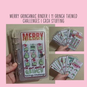 Può includere: Un raccoglitore trasparente con una copertina e inserti a tema Grinch. La copertina presenta il testo "MERRY GRINCHMAS" e "THE MANY MOODS OF GRINCH Savings Challenge". Gli inserti hanno disegni e testo a tema Grinch.