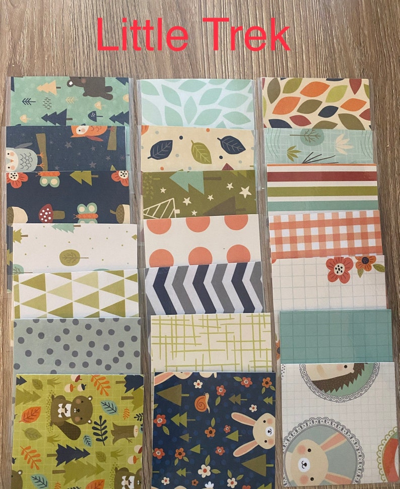 May include: A set of 12 patterned paper sheets with a woodland theme. The papers feature various designs, including owls, butterflies, trees, stars, and geometric patterns. The papers are perfect for scrapbooking, card making, and other paper crafts.