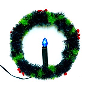 May include: A Christmas wreath with a black and green garland, red berries, and a blue light bulb candle. The wreath is circular and has a black power cord.