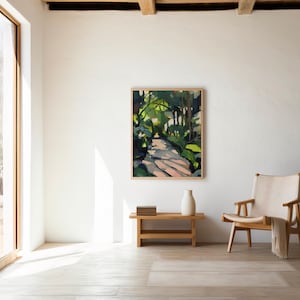 May include: An abstract painting in a wooden frame shows a path through a forest, with green and brown hues. The artwork is displayed on a white wall in a bright room, with a wooden bench, a vase, and a chair with a cream throw.