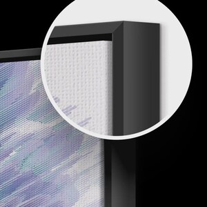 May include: Close-up of a framed canvas art piece. The artwork features a blend of blue and purple brushstrokes. The canvas is set within a sleek, black frame, creating a modern aesthetic.