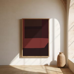 Può includere: Un'opera d'arte murale rettangolare in una cornice di legno chiaro che presenta una composizione astratta di forme geometriche solide e stratificate in tonalità profonde di bordeaux, marrone scuro e nero, creando un audace effetto visivo.