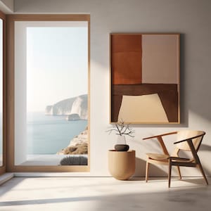May include: Interior scene with a framed abstract artwork in shades of brown and white. A wooden chair, a decorative vase with a plant, and a wooden side table are in the foreground. A large window offers a view of the sea and cliffs.