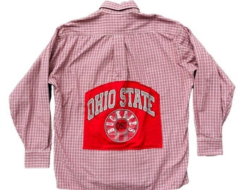 May include: A red and white plaid long-sleeve button-up shirt with a red patch on the back that says "Ohio State" with a circle that says "Buckeyes OSU" inside.