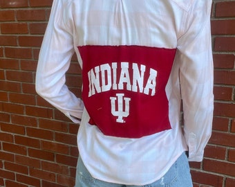 May include: A white and pink plaid button-up shirt with a red patch on the back that says "INDIANA" with a white "IU" logo.