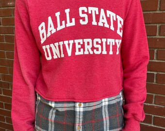 May include: Red long-sleeved sweatshirt with a white "Ball State University" graphic. The sweatshirt is cropped and has a plaid flannel shirt layered underneath.