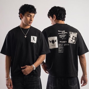 May include: Black t-shirts with graphic designs. One has a white patch with a stylized "L" and text. The other displays a patch with a heart and text, along with the phrase "This world is rotten, and those who are rotten".