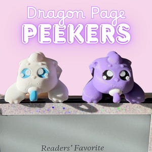 Puede incluir: Dos marcadores de página con forma de dragón, uno blanco con detalles azules y otro morado, están sobre una tableta. El texto "Dragon Page PEEKERS" está encima. El dragón blanco tiene una lengua azul, y el dragón morado tiene una lengua blanca.