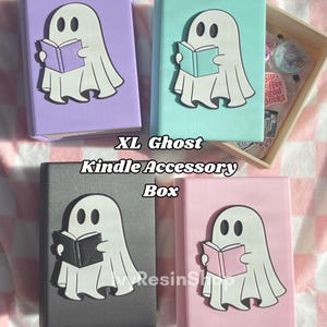May include: Four XL Ghost Kindle Accessory Boxes in pastel colors: purple, mint green, gray, and pink. Each box features a white ghost design reading a book. The text "XL Ghost Kindle Accessory Box" is printed on the image.