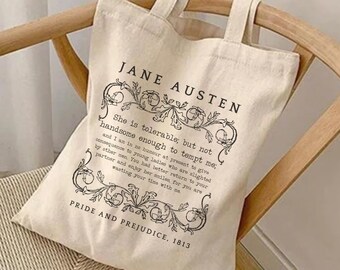 May include: A natural-colored canvas tote bag featuring black printed text and decorative floral borders. The text reads Jane Austen, Pride and Prejudice, 1813, and a quote from the novel. The bag has two fabric handles and a rectangular shape.