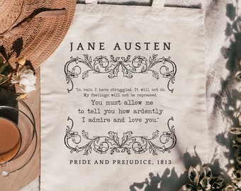 May include: A cream-colored canvas tote bag featuring black printed text that reads Jane Austen, Pride and Prejudice, 1813, and a quote from the novel. The design includes decorative floral scrollwork borders above and below the central text.