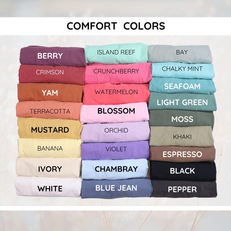 以下が含まれることがあります： 「COMFORT COLORS」と題されたカラーチャートで、ベリー、クリムゾン、ヤム、テラコッタ、マスタード、バナナ、アイボリー、ホワイト、アイランドリーフ、クランチベリー、ウォーターメロン、ブロッサム、オーキッド、バイオレット、シャンブレー、ブルージーン、ベイ、チョーキーミント、シーフォーム、ライトグリーン、モス、カーキ、エスプレッソ、ブラック、ペッパーなどの様々な色合いの折りたたまれたTシャツが表示されています。