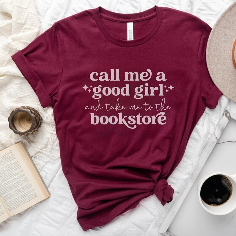May include: Burgundy t-shirt with the text "Call me a good girl and take me to the bookstore" in white.