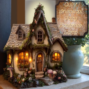 May include: A miniature house sculpture lamp with a shingled roof, arched windows, and a wooden door. The structure is adorned with moss, small flowers, and mushrooms. Warm light glows from within the windows. Text reads: Quint Whimsical Fairy Sculpture Lamp.