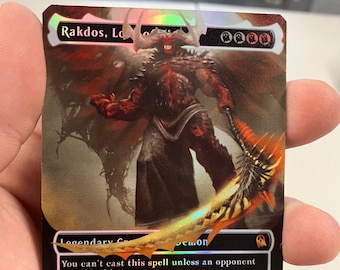 Puede incluir: Una carta de Magic: The Gathering negra y roja que representa a Rakdos, Señor de los Motines, con una ilustración de un demonio. El texto de la carta dice "No puedes lanzar este hechizo a menos que un oponente haya perdido vida este turno. Vuelo, arrollar. Los hechizos de criatura que lanzas cuestan 1 menos de lanzar por cada 1 de vida que tus oponentes hayan perdido este turno." La carta es una criatura 6/6.