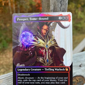 May include: A black and red Magic: The Gathering card with a purple and gold illustration of a Tiefling Warlock named Prosper, Tome-Bound. The card text reads "Legendary Creature - Tiefling Warlock". "Deathtouch". "Mystic Arcanum - At the beginning of your end step, exile the top card of your library. Until the end of your next turn, you may play that card.". "Pact Boon - Whenever you play a card from exile, create a Treasure token.". "1/4".